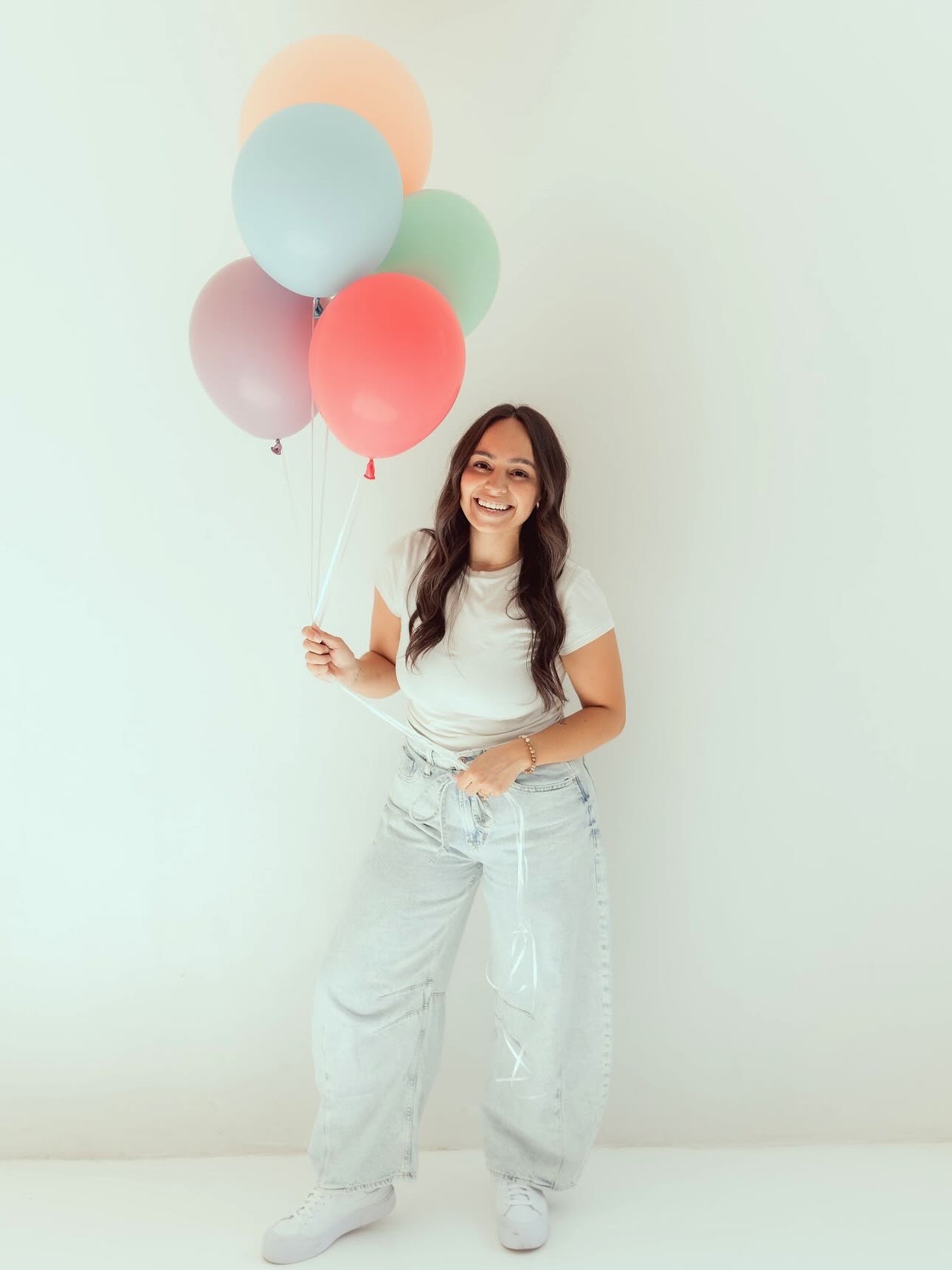 AZ Party Co. balloon designer holding a bunch of pastel balloons