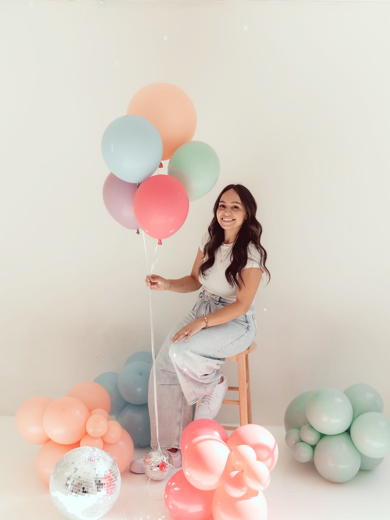 AZ Party Co. designer with pastel balloons and disco balls in the studio