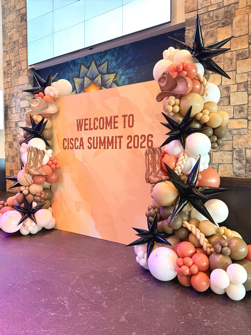 Western-themed CISCA Summit 2026 corporate balloon backdrop with black star balloons, cowboy hats and boots by AZ Party Co.
